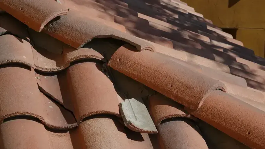 Cracked and slipped clay roof tiles where wind-driven rain gets under the roof